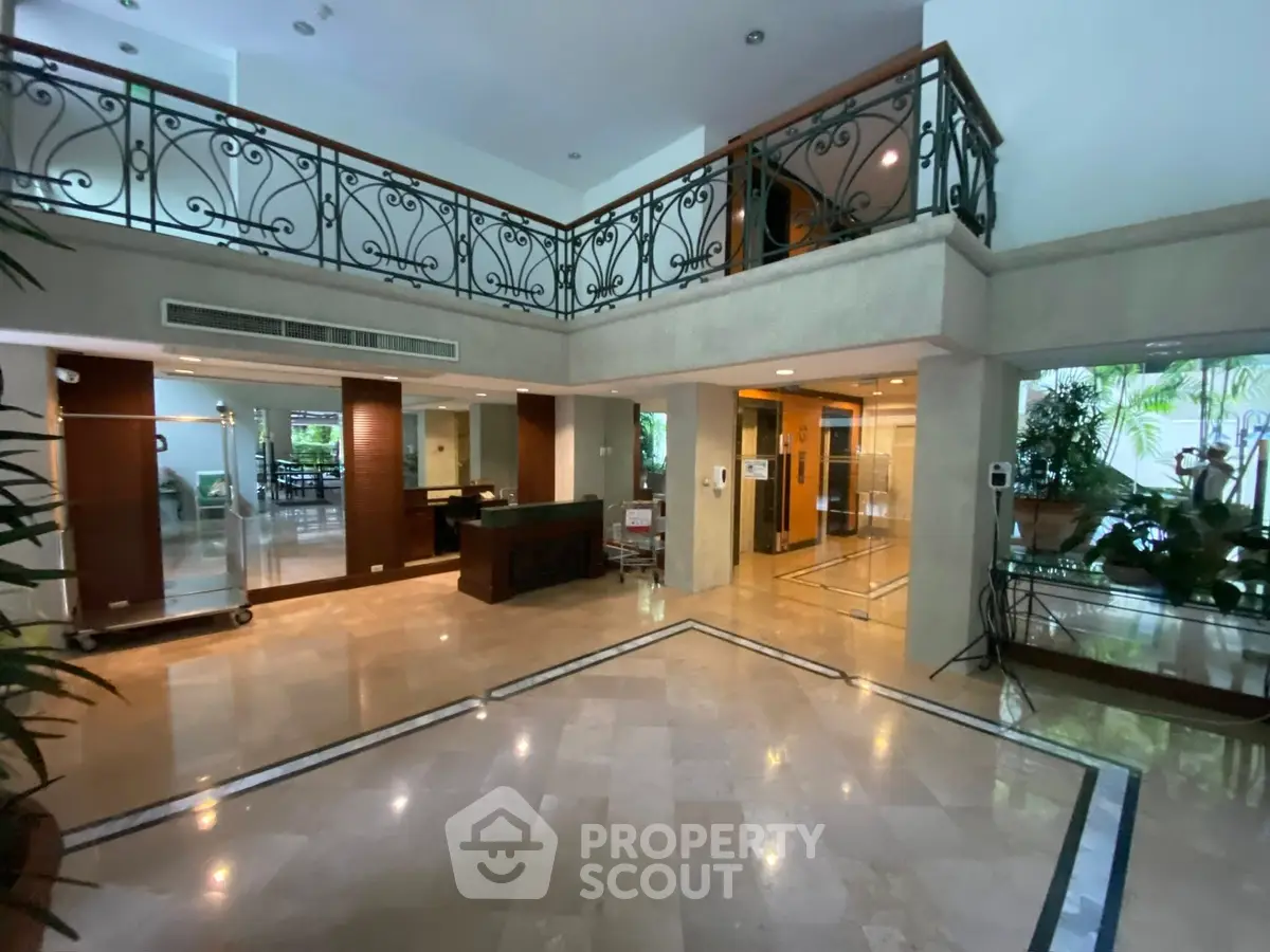 Elegant building entrance with marble floors and stylish railing, offering a welcoming ambiance.