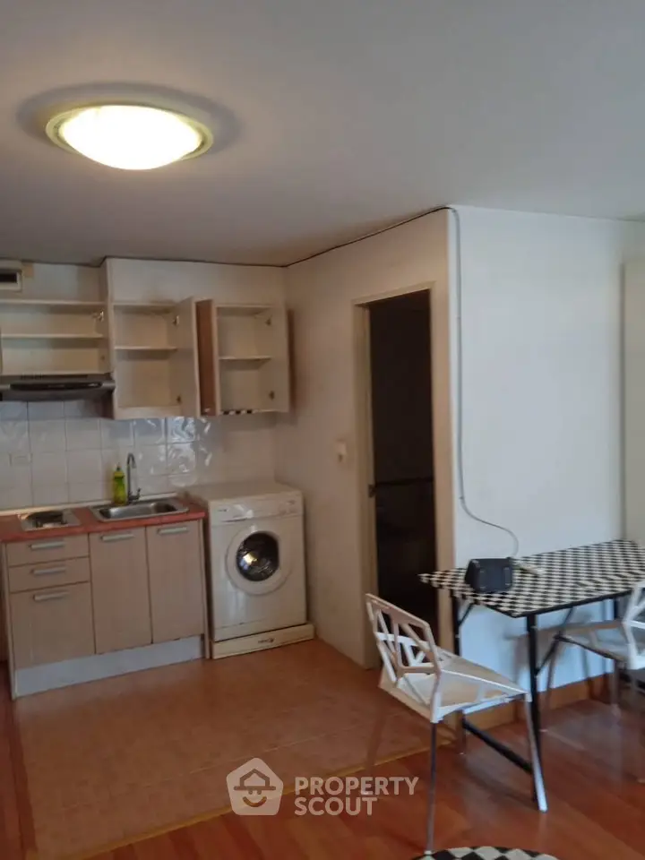 Cozy kitchen with washing machine and dining area in modern apartment
