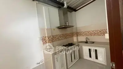 Compact kitchen with gas stove and modern cabinetry in a cozy apartment