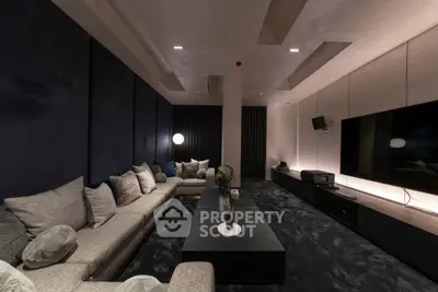 Luxurious home theater room with plush seating and large screen TV