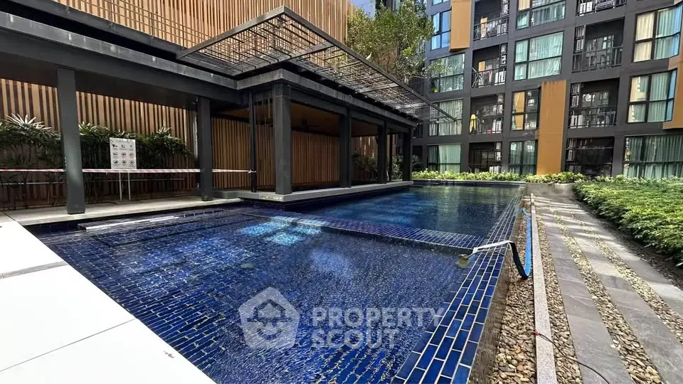 Modern apartment complex with luxurious outdoor pool and stylish architecture.