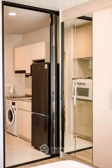 Modern kitchen with sleek appliances and washing machine in compact layout