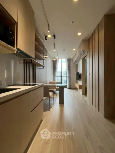 Modern open-layout kitchen and living area with sleek wooden finishes and city view.