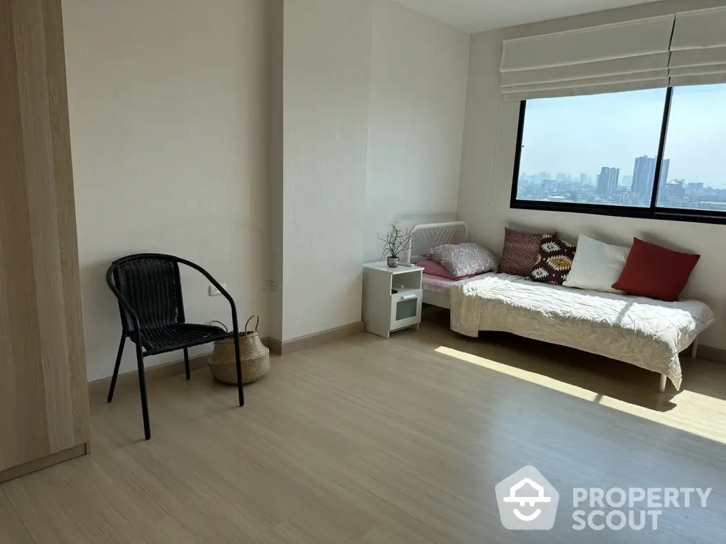 Bright and airy bedroom with city view, featuring minimalist decor and natural light.