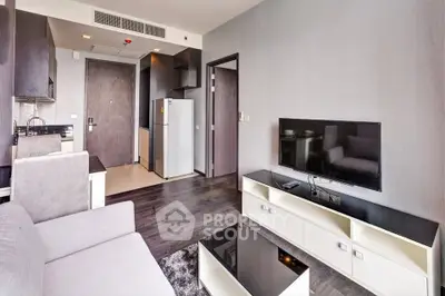 Modern living room with sleek furniture and open kitchen layout in a stylish apartment.