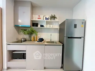 Modern compact kitchen with sleek cabinets and stainless steel fridge