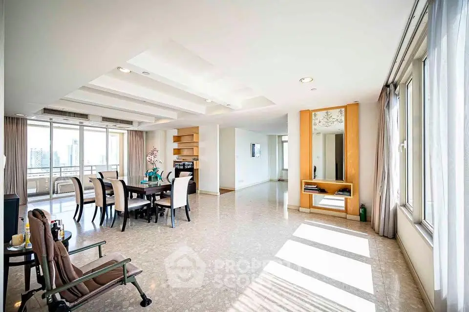 Spacious and sunlit living room with dining area and large windows in modern apartment.