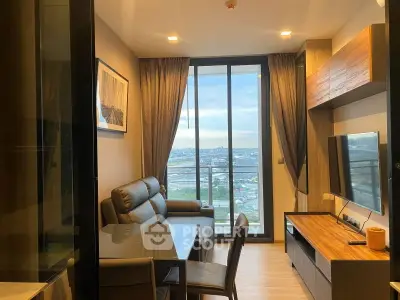 Modern living room with city view, sleek furniture, and large windows for natural light.