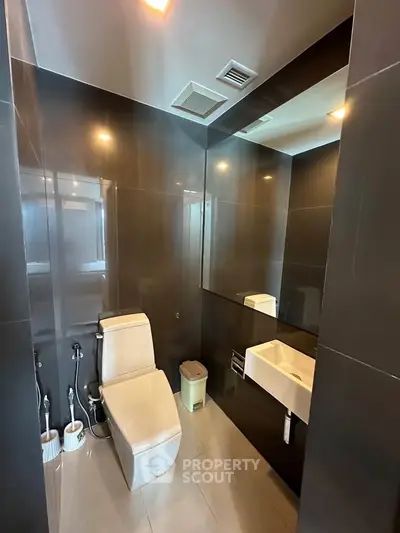 Modern bathroom with sleek dark tiles and contemporary fixtures
