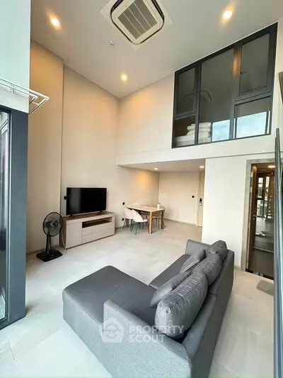 Modern loft-style living room with high ceilings and sleek furnishings
