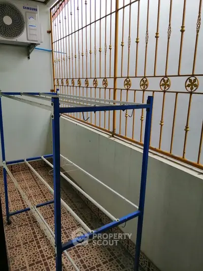 Compact balcony with decorative railing and air conditioning unit, ideal for urban living.