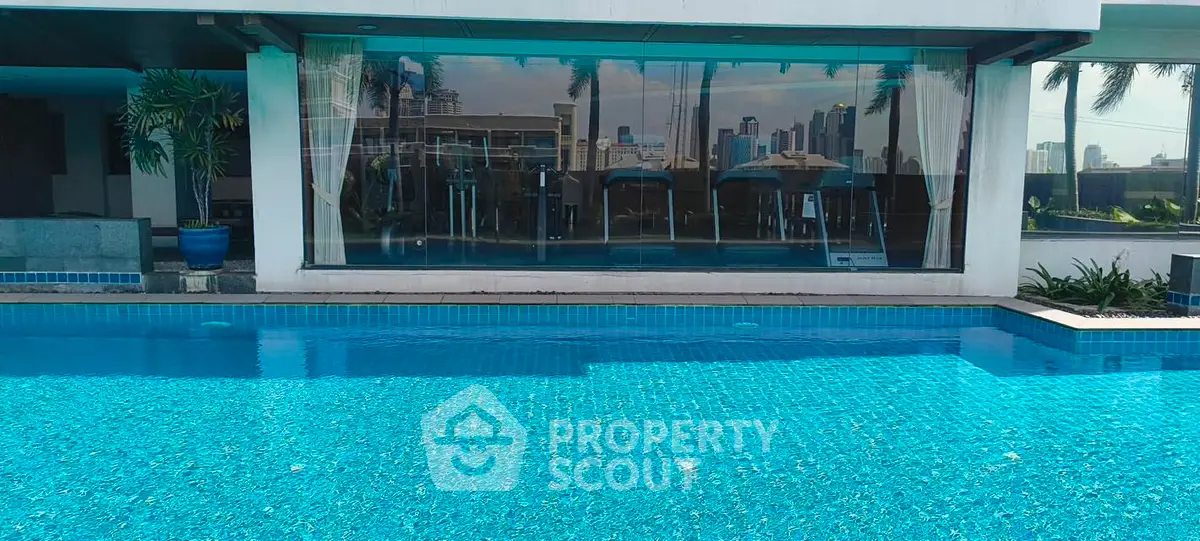Luxurious rooftop pool with city skyline view and modern gym facilities.