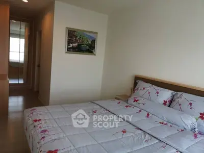 Cozy bedroom with floral bedding and wooden accents in modern apartment.