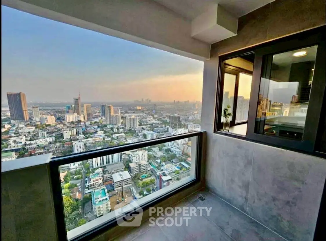 Stunning high-rise balcony with panoramic city view at sunset, perfect for urban living.