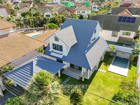 Stunning aerial view of a modern house with a spacious garden and private pool in a serene neighborhood.