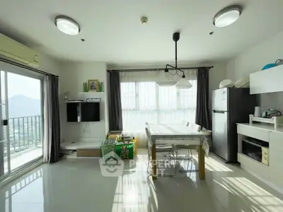 Bright and modern living room with dining area and balcony view, featuring sleek furniture and natural light.