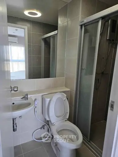 Modern bathroom with sleek shower and compact design in urban apartment.