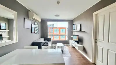 Modern living room with stylish decor and large window offering city view.