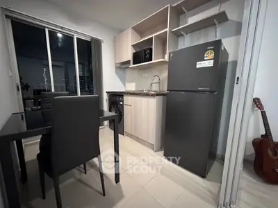 Modern kitchen with sleek appliances and dining area in a stylish apartment.