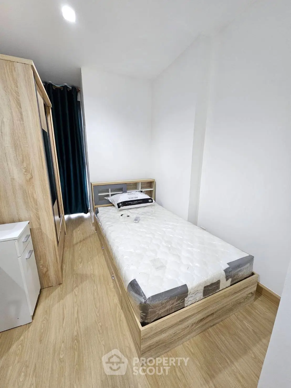 Modern minimalist bedroom with wooden flooring and sleek furniture design.