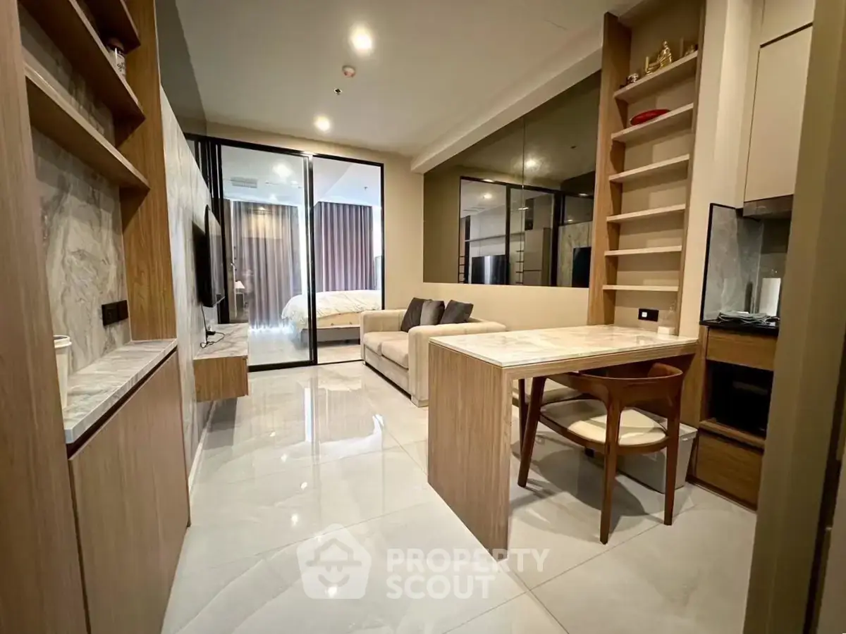 Modern open-plan living room with sleek kitchen and cozy dining area in a stylish apartment.