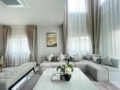 Luxurious living room with high ceilings, elegant curtains, and plush seating for ultimate comfort.