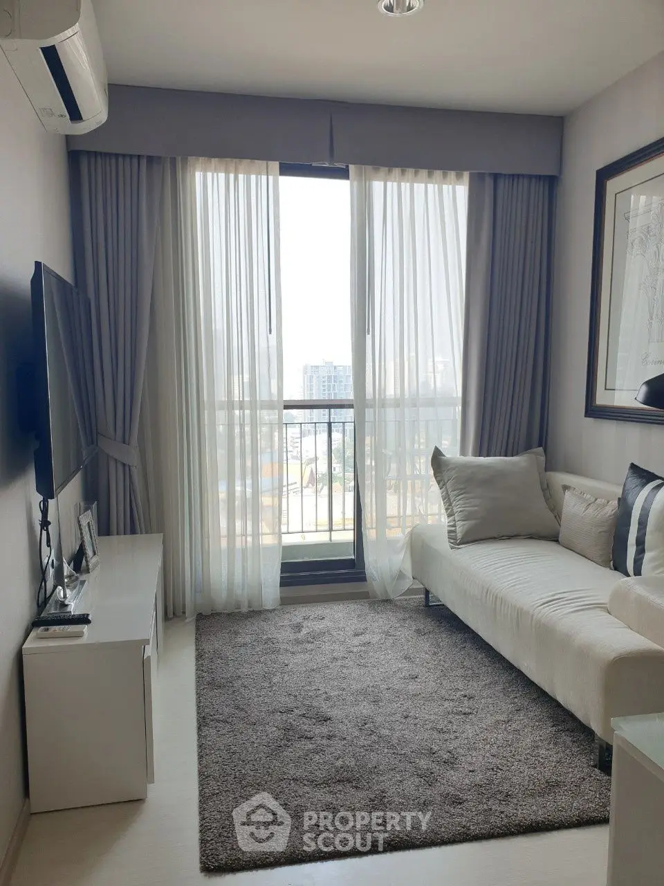 Cozy living room with large window and modern decor in urban apartment.