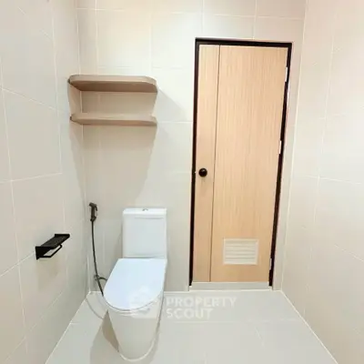 Modern minimalist bathroom with sleek fixtures and wooden door