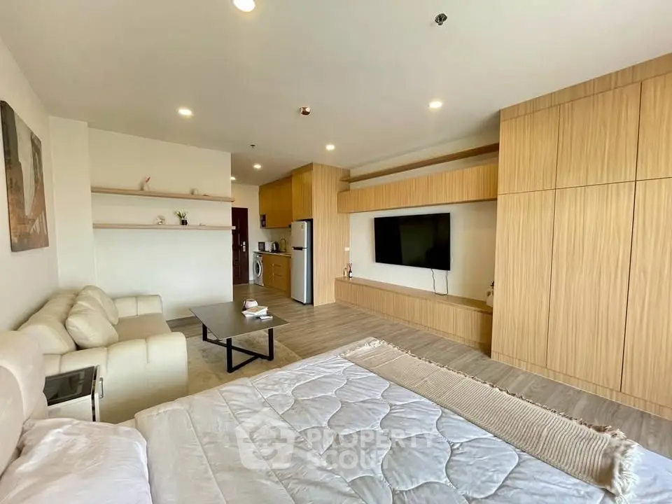 Spacious modern living room with integrated kitchen and stylish wood paneling.