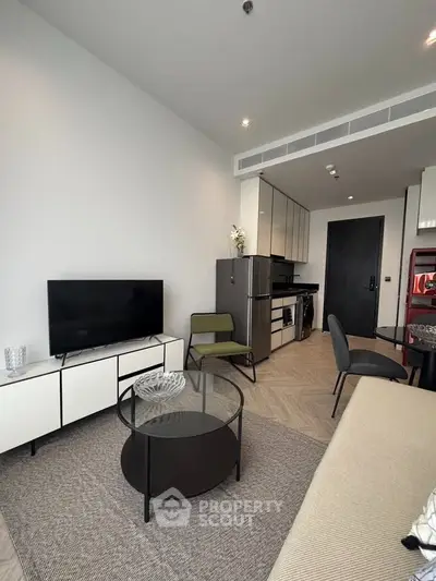 Modern living room with sleek furniture and open kitchen layout in a stylish apartment.