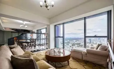 Luxurious living room with panoramic city view and elegant furnishings.