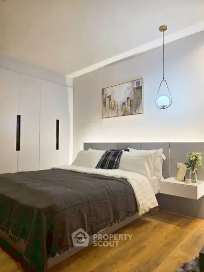 Modern bedroom with stylish pendant light and built-in wardrobe