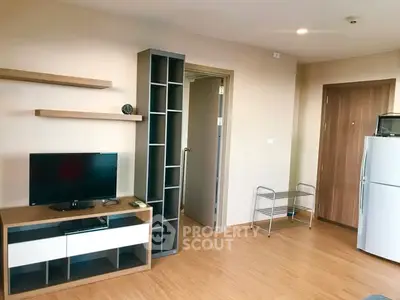 Modern living room with TV, shelves, and refrigerator in a cozy apartment.