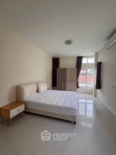 Spacious bedroom with modern furnishings and natural light