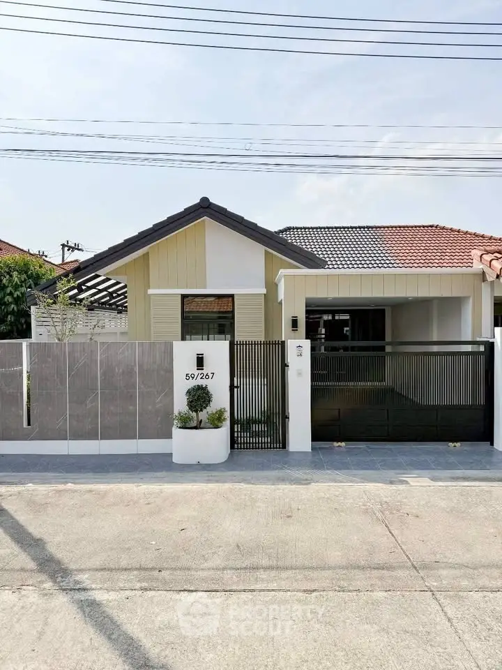 Charming single-story house with modern facade and gated entrance in a serene neighborhood.