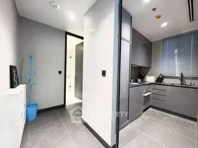 Modern kitchen with sleek gray cabinets and open layout in a contemporary apartment.