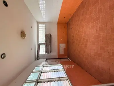 Spacious kitchen with tiled walls and large windows for natural light.