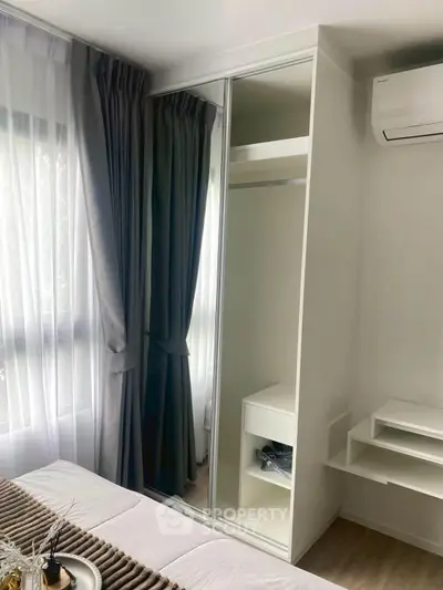 Modern bedroom with mirrored wardrobe and air conditioning unit