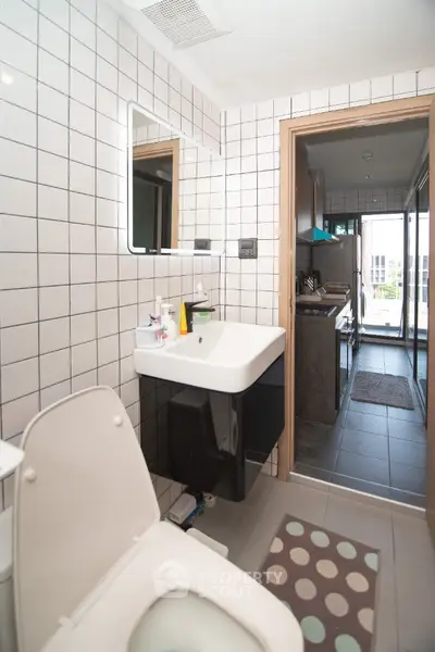 Modern bathroom with sleek design and tiled walls in a contemporary apartment.