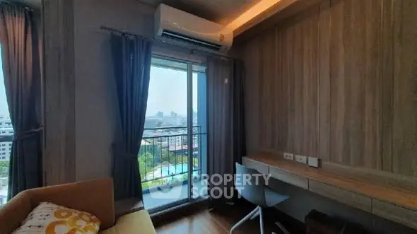 Modern living room with balcony and city view, featuring stylish furniture and air conditioning.