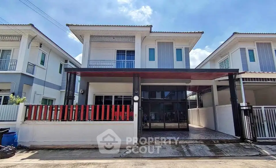 Modern two-story house with a sleek facade and spacious driveway in a suburban neighborhood.