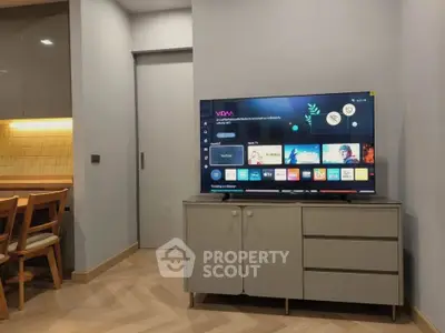 Modern living room with sleek TV setup and stylish dining area, perfect for contemporary living.