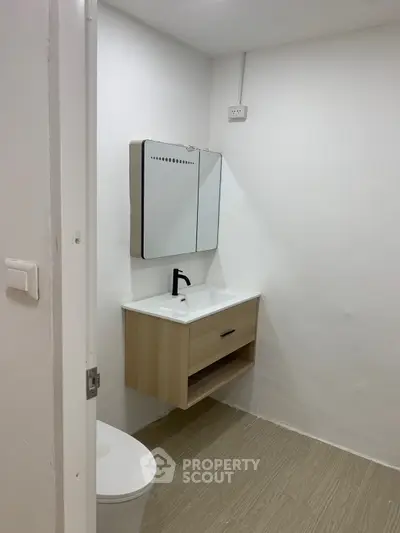 Minimalist bathroom with modern vanity and mirror in a sleek design.