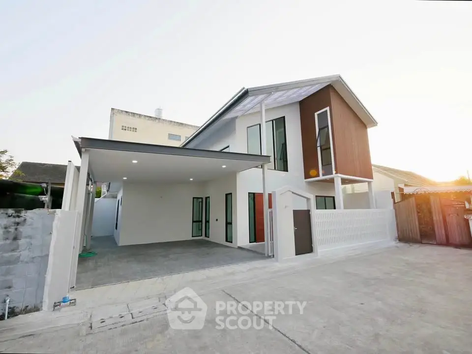 Modern two-story house with sleek design and spacious driveway in a serene neighborhood.