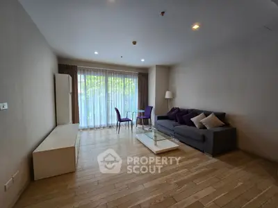 Spacious living room with modern furniture and large window for natural light.