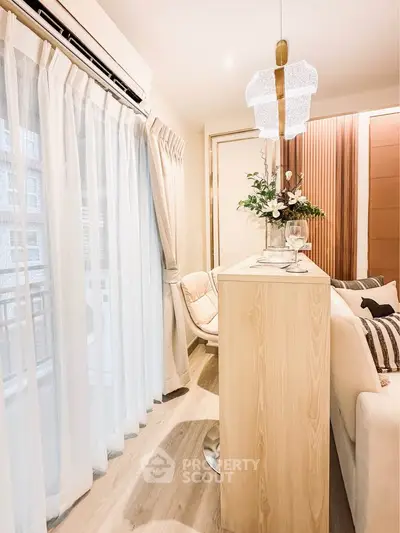 Elegant living room with modern decor and natural light, featuring a cozy seating area and stylish lighting.