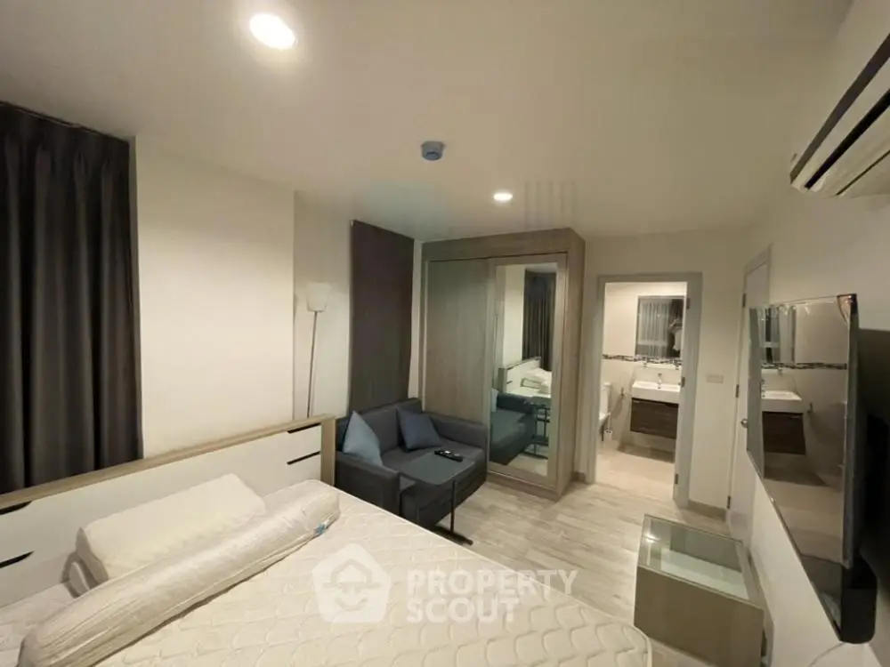 Modern bedroom with cozy lighting and stylish decor, featuring a comfortable bed and mirrored wardrobe.