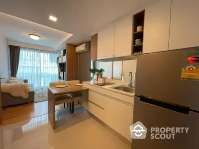 Modern open-layout kitchen and living room with sleek design and ample natural light.