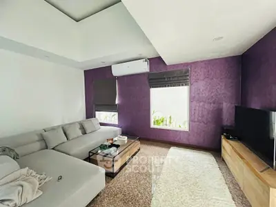 Modern living room with stylish purple accent wall and cozy sectional sofa