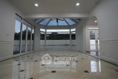Spacious living room with large windows and elegant flooring, perfect for natural light and modern living.